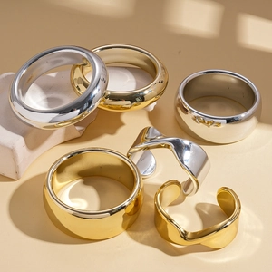 Set of 6 minimalist geometric rings in gold and silver finish on white rock prop