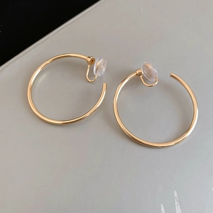Detail of golden hoop clip earrings with soft transparent silicone pads for comfort