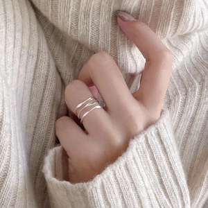 Elegant 925 sterling silver wavy cross open ring on model with beige knit sweater