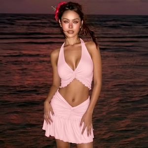 Sunset view of a pink two-piece beach set featuring a halter top and ruffled skirt