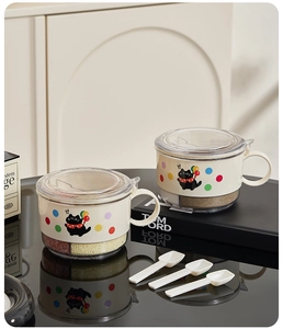 Detail view of round 4-grid beige spice jars with cat motifs and small white spoons