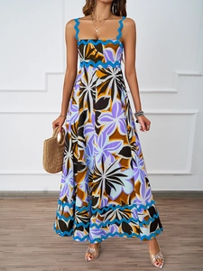 Detailed close-up of a long floral print vacation dress with wavy ribbon trim