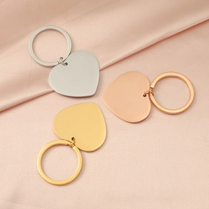 Close-up of heart-shaped metal keychains in silver gold and rose gold on silk fabric