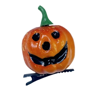 Halloween pumpkin hair clip with smiling face and green stem on black metal duckbill clip