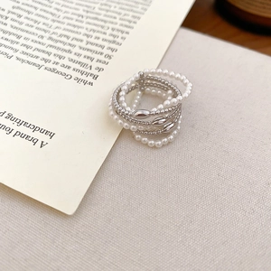 Detailed macro view of multi-layer faux pearl beaded ring with silver metal accents