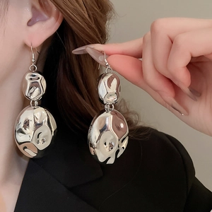 Polished silver irregular liquid geometric earrings on model for stylish look