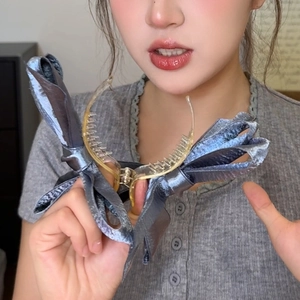 Detail of grey-blue satin triple bow banana clip showing fabric texture and claw teeth