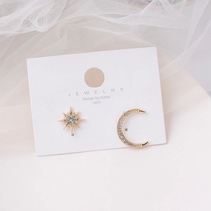 Macro detail of asymmetric gold star and moon earrings with S925 silver needles