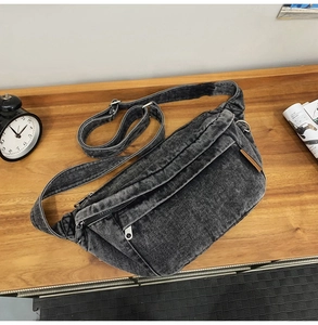 Flat lay of vintage washed black denim crossbody bag on a wooden table with accessories