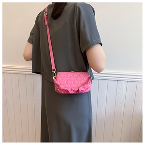 Fashionable pink sequin crossbody bag with metallic floral accents shown on a model