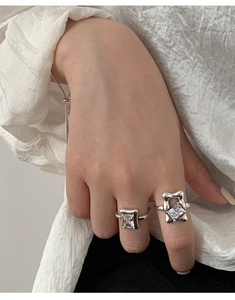 Detailed close-up of 925 silver rings with square stones on model's fingers