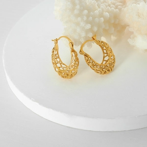 Golden hollow geometric hoop earrings with mesh texture on a minimalist white display