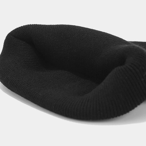 Macro detail of high-quality black knit beanie showing thick ribbing and double-layer texture