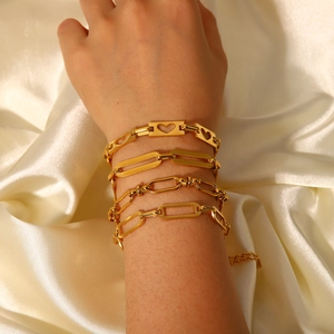 Set of 4 gold stainless steel layered bracelets featuring hollow heart and chain links