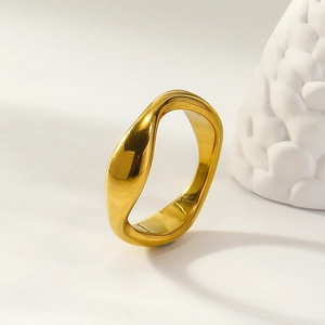 Minimalist irregular wave-shaped gold ring with a polished mirror finish on white background