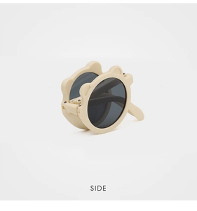Side view of foldable kids sunglasses with cream bear ears and dark grey lenses