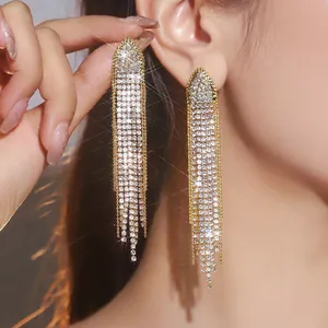 Detail of long gold tassel earrings with shimmering rhinestones and elegant drop design