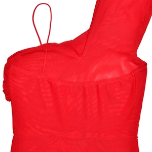 Détail d'une robe en maille rouge montrant la coupe asymétrique et la texture du tissu