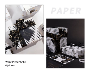Detail of luxury gift wrapping set with gold star paper, black ribbons and thank you cards