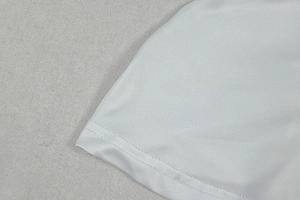 Detailed macro shot of white dress stitching and high-quality knitted fabric texture