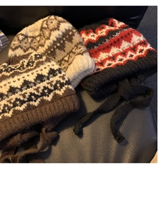 Detailed close-up of knitted winter hats with earflaps in various colorful vintage patterns