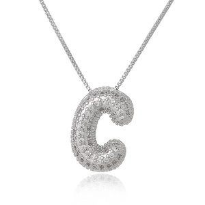 Macro shot of silver letter C pendant with shimmering cubic zirconia micro-pave setting