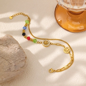 Detail of gold titanium steel double-layer bracelet with tree of life charm and beads