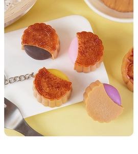 Nahaufnahme von verschiedenen Mooncake Squishy Anti-Stress-Spielzeugen mit Metallanhängern