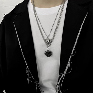 Detail of a silver double-layered titanium steel necklace with heart pendants on a model