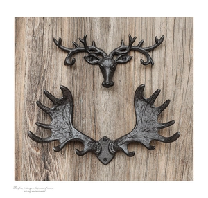 Detailed macro view of vintage cast iron antler wall hooks on a rustic wood background