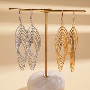 Close-up of geometric hollow layered metal earrings on a professional T-stand