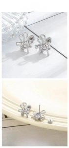 Macro shot of silver bow stud earring with screw back on a vintage ceramic plate