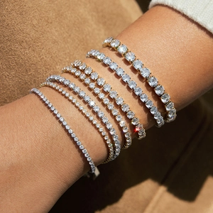 Vari bracciali tennis in oro e argento con zirconi indossati da una modella
