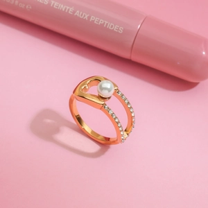 Vue macro de la bague en or 18k avec cœur évidé, perle d'imitation et cristaux latéraux