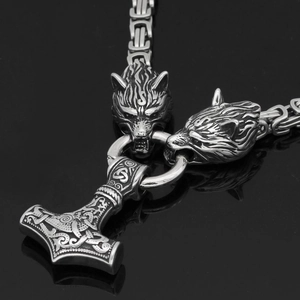 Détail macro du pendentif Mjölnir avec nœuds celtiques et têtes de loup viking