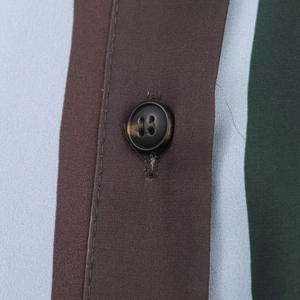 Macro detail of high-quality striped satin shirt showing stitching and a black button