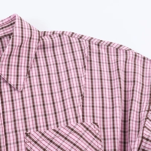 Gros plan sur la chemise à carreaux rose et marron montrant le col et la poche de poitrine