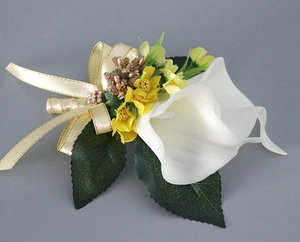 Detail of calla lily wedding boutonniere with champagne ribbon and golden trim