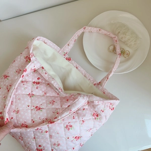 Close-up of pink floral quilted cotton tote bag with detailed rhombus stitching pattern