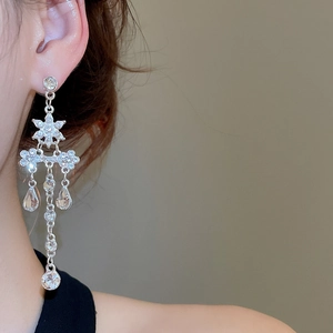 Gros plan de boucles d'oreilles pendantes argentées avec fleurs en zircon sur mannequin