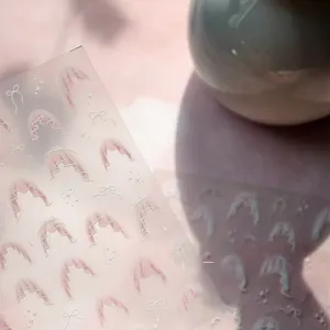 Macro detail of sweet pink lace nail stickers with white bows and starry patterns