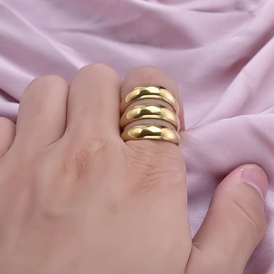 Set of three stackable 304 stainless steel gold dome rings for women on purple fabric