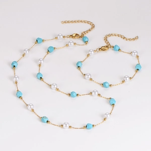 Set dettagliato di collana e bracciale dorati con perle bianche e perline turchesi