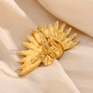 Detailed close-up of a 18K gold plated sunburst open ring on elegant white silk
