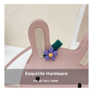 Detailed macro view of pink rabbit child purse featuring purple flower and green strap