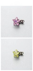 Macro detail of 6mm star-shaped zircon dermal anchor tops with colorful claw setting