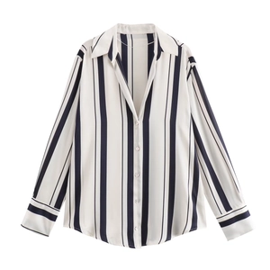 Détail d'une chemise en satin blanc à rayures verticales bleu foncé et boutons