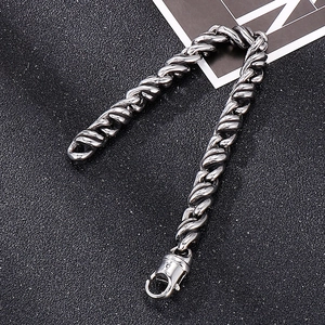 Bracelet robuste en acier inoxydable torsadé pour hommes avec fermoir mousqueton sur fond noir