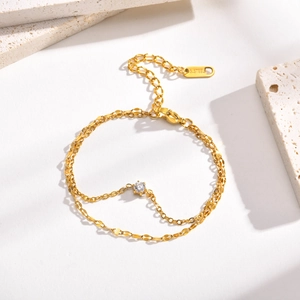 Gros plan d'un bracelet double couche en acier doré avec un cristal de zircon rond