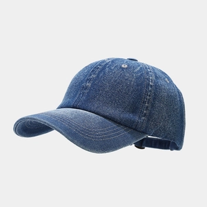 Detail view of washed blue denim baseball cap showing six-panel stitch and curved brim